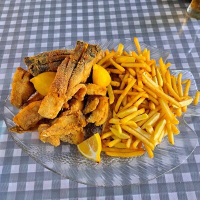 Pečeni smuđ sa prilogom u ovalu na stolu